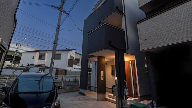A modern two-story building with a garage and a car parked in front. - OYADO - Self Check-In Only (Osaka)