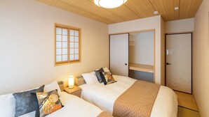 A hotel room with two beds, a wooden ceiling, a window with a grid pattern, and a wardrobe with a mirror. - OYADO - Self Check-In Only (Osaka)