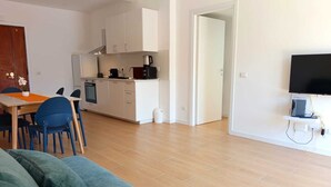 A modern apartment with a kitchen, dining area, and living room.