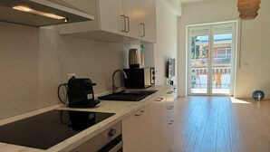 A modern kitchen with a built-in oven, a coffee machine, and a sink.