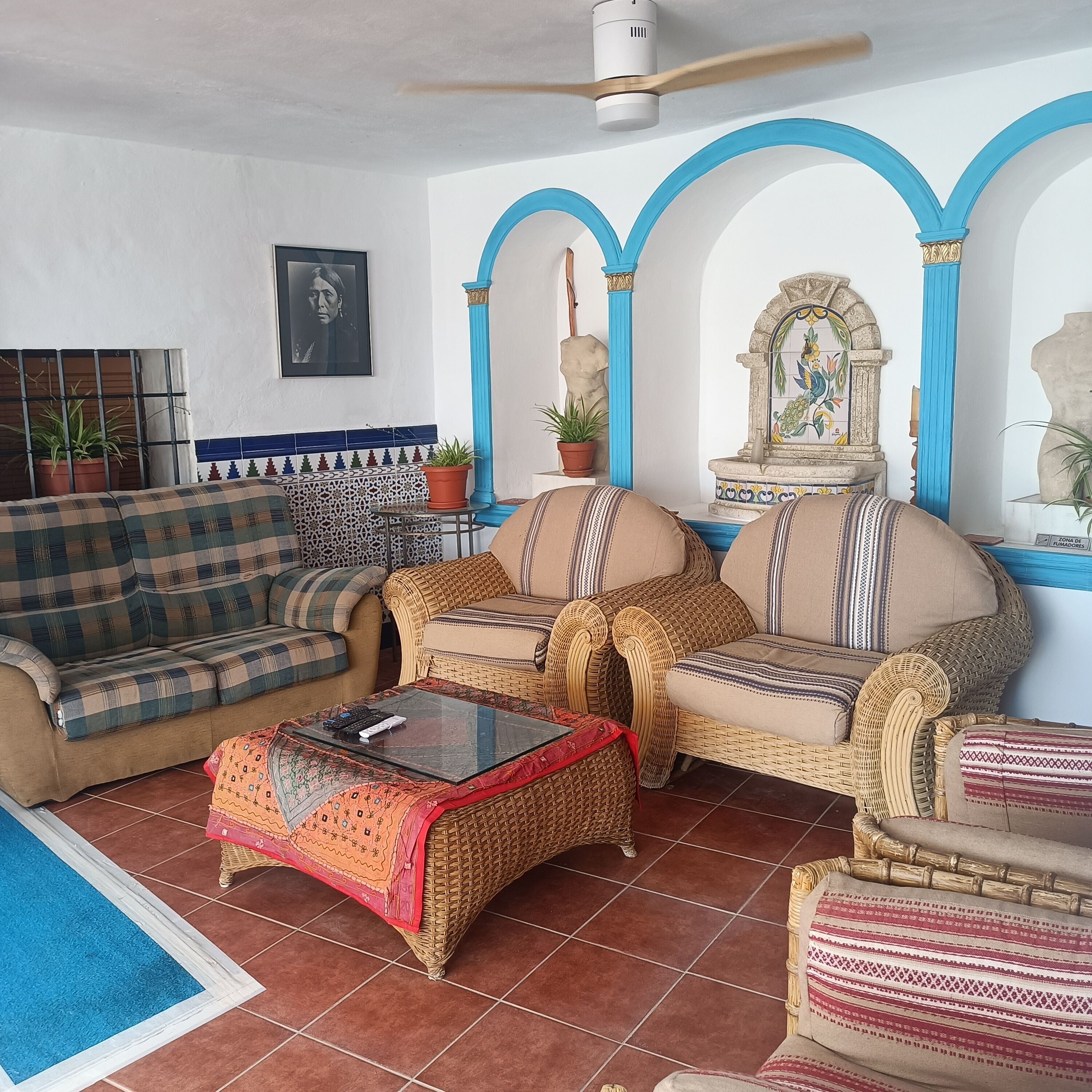 Een woonkamer met een bank, fauteuils, een bijzettafeltje en een decoratieve fontein.