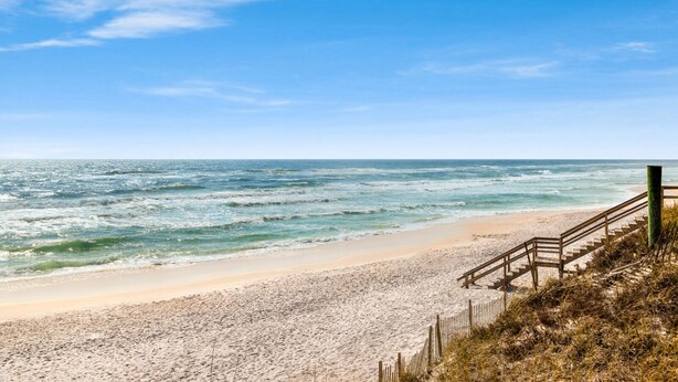 A beach with a wooden staircase leading down to the shore, a sandy beach, and the ocean. - IndiGo Blue- Golf Cart! Pool & Fitness Center (Santa Rosa Beach)