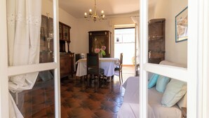 Une pièce comprenant une table à manger, des chaises, un lustre et un lit avec des oreillers.