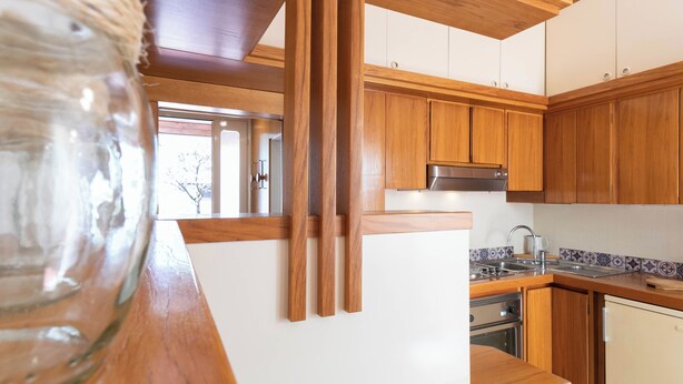 Une cuisine moderne avec des meubles en bois, un évier en acier inoxydable et un four encastré.