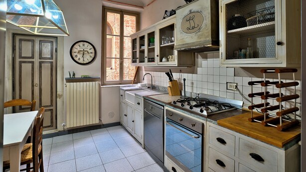 A kitchen with white cabinets, a stove, a sink, and a window. - Corte Dei Portici - Three Bedroom Apartment, Sleeps 6 (Lucca)