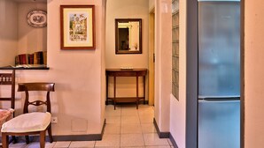 A kitchen with a refrigerator, a dining table with chairs, a mirror, and a framed picture on the wall. - Corte Dei Portici - Three Bedroom Apartment, Sleeps 6 (Lucca)