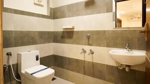 A bathroom with a toilet, sink, and shower. - Royal Plaza City (Kozhikode)