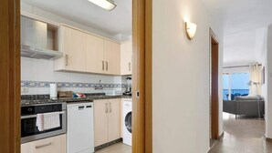 Une cuisine moderne équipée d’un lave-vaisselle, d’un four et d’un lave-linge.