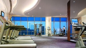 Un gimnasio con cintas de correr, elípticas y equipo de pesas.