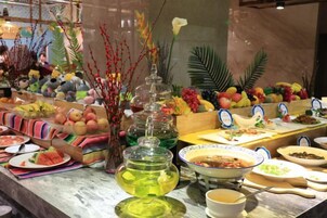 A buffet with various food items and a decorative centerpiece.