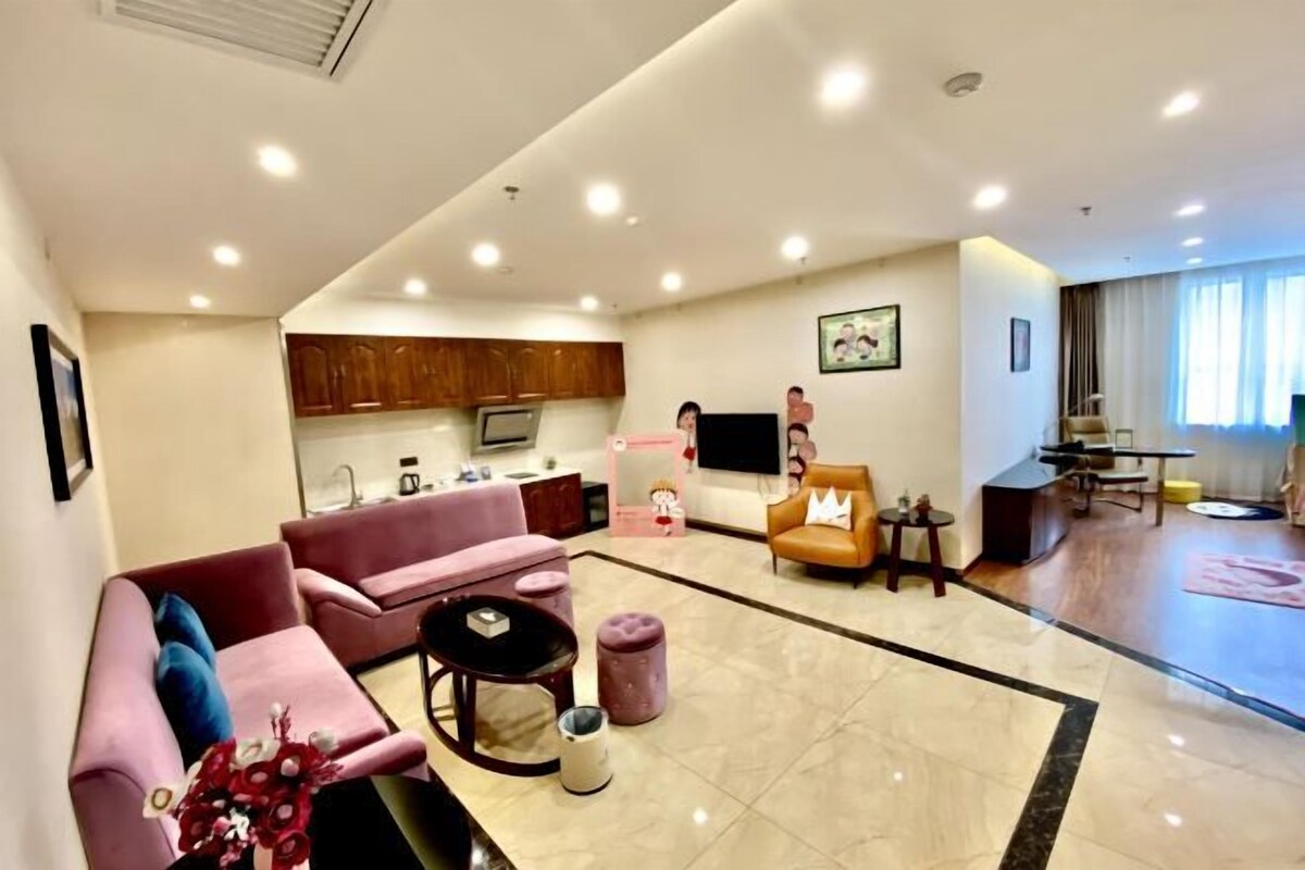 A spacious living area with a sofa, a coffee table, and a television.