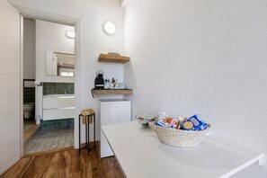 A compact kitchen with a refrigerator, a coffee maker, and a bowl of cereal on the counter. - Apartment 'Mirto' with shared pool, Wi-Fi and air conditioning (Alghero)