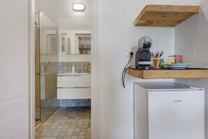 A compact kitchen with a coffee maker, a refrigerator, and a wooden shelf above the counter. - Apartment 'Rosmarino' with shared pool, Wi-Fi and air conditioning (Alghero)