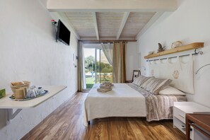 A bedroom with a bed, bedside table, and a TV mounted on the wall. - Apartment 'Rosmarino' with shared pool, Wi-Fi and air conditioning (Alghero)