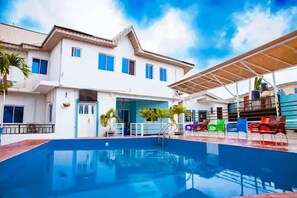 A two-story building with a swimming pool in the foreground. - The Kings Hotel and Suites  (Ibadan)