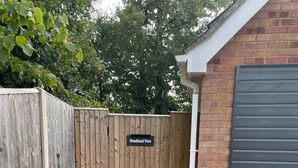Una puerta de madera con la leyenda 'Woodland View' que da a un sendero de grava.