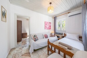 Une chambre à coucher avec un lit, un canapé, un bureau et une fenêtre.