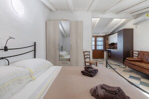 Une chambre à coucher avec un lit, une chaise, un canapé et un miroir.