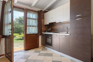 A kitchen with a built-in oven, a stove, and a sink.