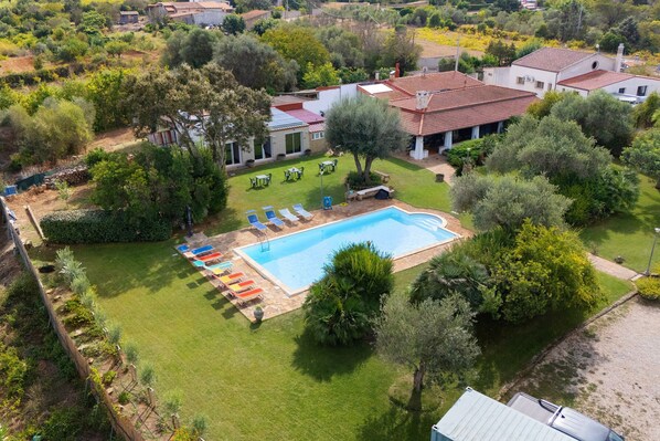 A residential property with a swimming pool, outdoor seating, and a well-maintained garden.