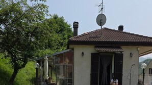 A house with a satellite dish, a chimney, and a small porch.