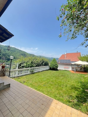 Un patio con vista a una casa y montañas.