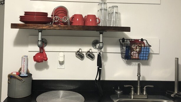 A kitchen with three wooden shelves, a clock, and a sink. - Cozy, centralized Studio in wonderful Houston with WiFi, AC (Houston)