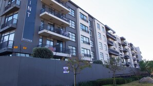 A multi-story apartment building with balconies, a sign reading "The Point Rivonia," and a gated entrance. - 2BR-2BA - Rivonia Residence 3 (Sandton)