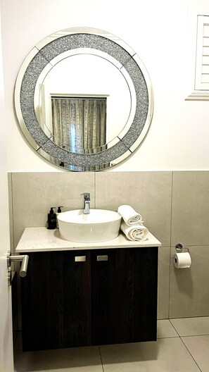 Een haardroger, handdoeken, zeep, toiletpapier