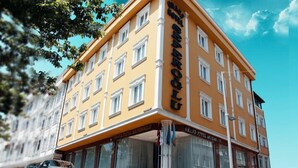 Un hotel de varios pisos con fachada amarilla y detalles blancos.