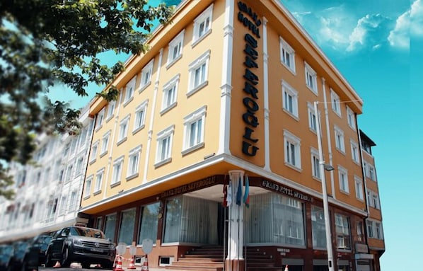 A multi-story hotel with a yellow facade and white trim.