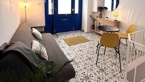 Una sala de estar moderna con una puerta azul, un sofá, una mesita y un espejo.