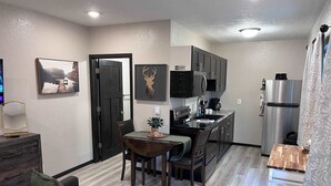 Un espace de vie compact comprenant un coin repas, une kitchenette et un canapé.