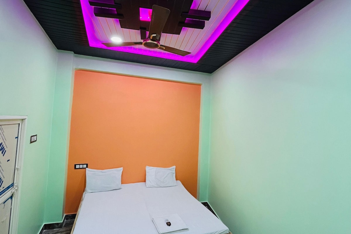 Een slaapkamer met een bed, een plafondventilator en een deur.