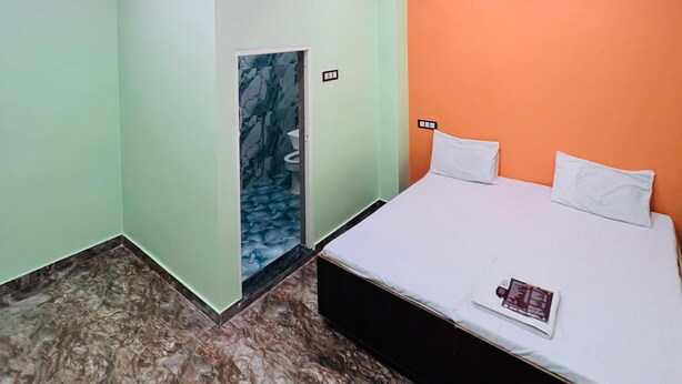 Un dormitorio con cama, ventilador de techo y puerta que da a un baño.