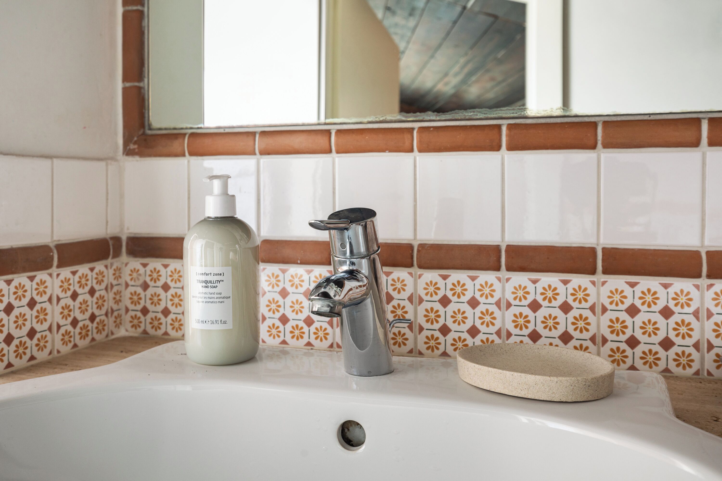 A bathroom sink with a soap dispenser and a faucet.