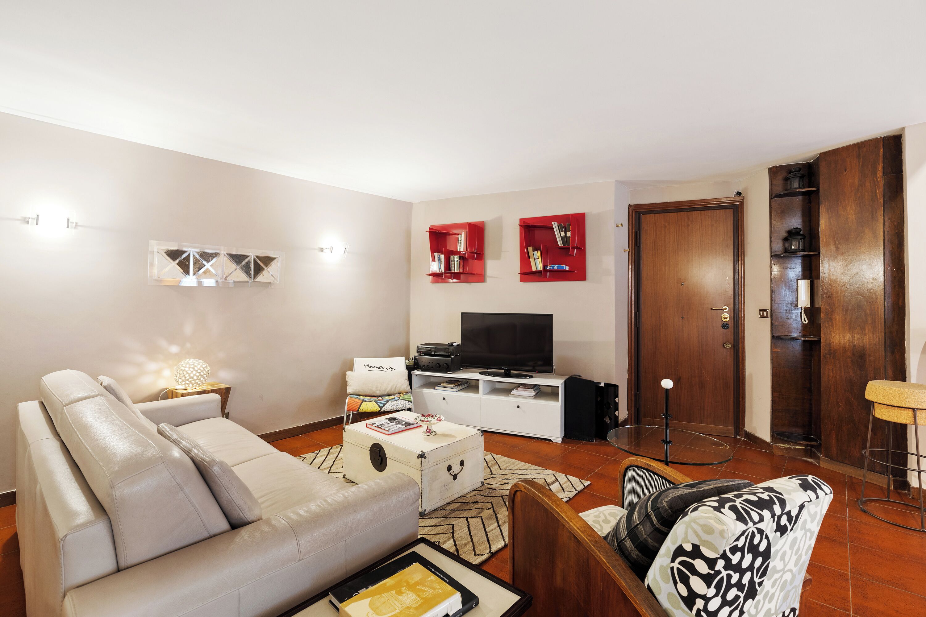 Ein Wohnzimmer mit einer Couch, einem Couchtisch, einem Fernseher und einem Bücherregal.
