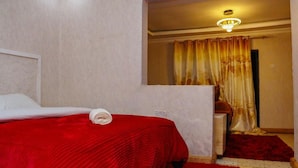 A hotel room with a bed, a desk, and a shower area. - Paradise Point Resort Naivasha (Nyahururu)