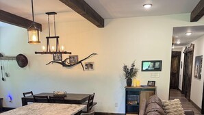 A modern kitchen with a central island, bar stools, and pendant lighting. - The Ancient Bear’s Den of the Forgotten Forest (Kodak)