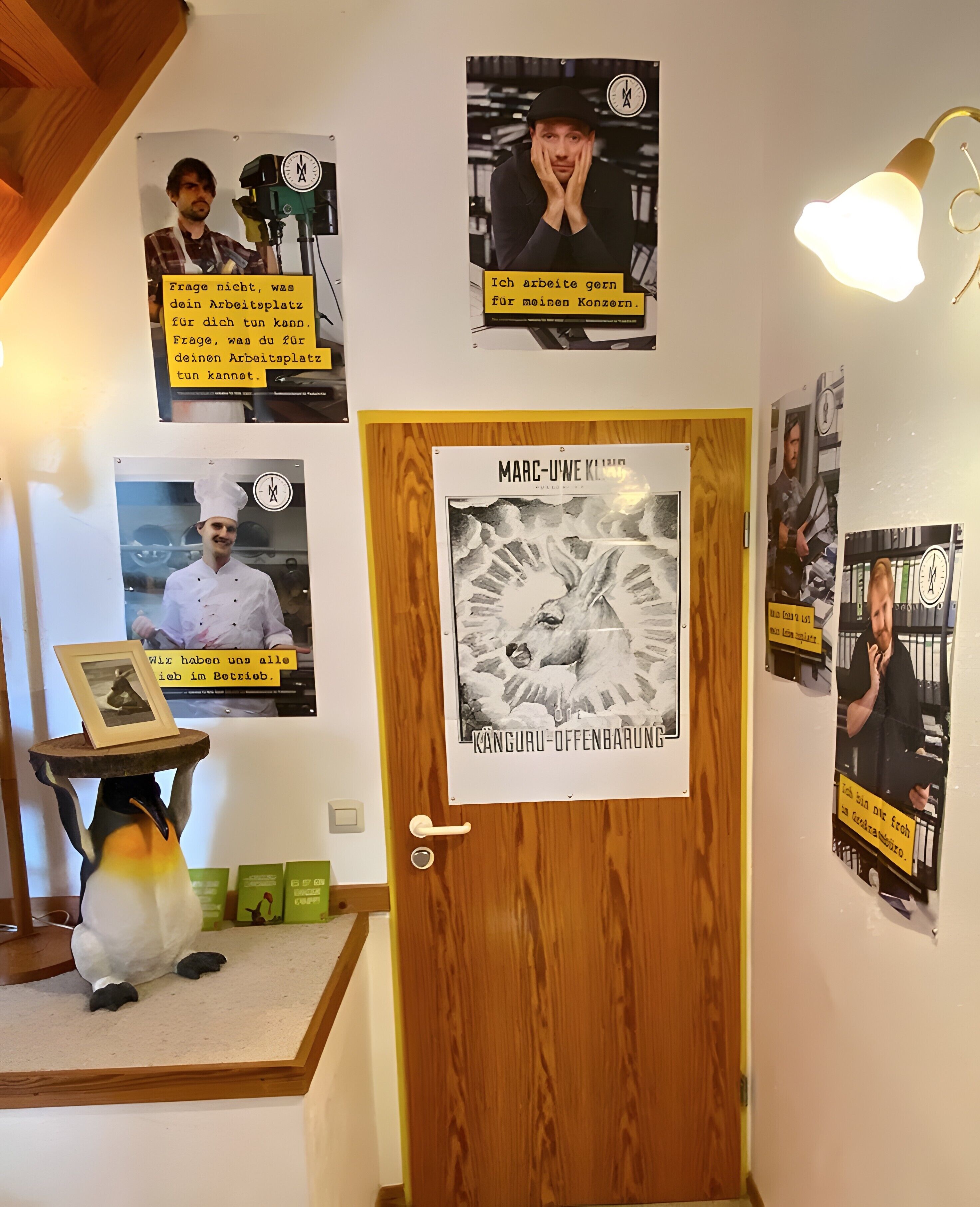 A hallway with wooden doors, posters, and a penguin decoration.