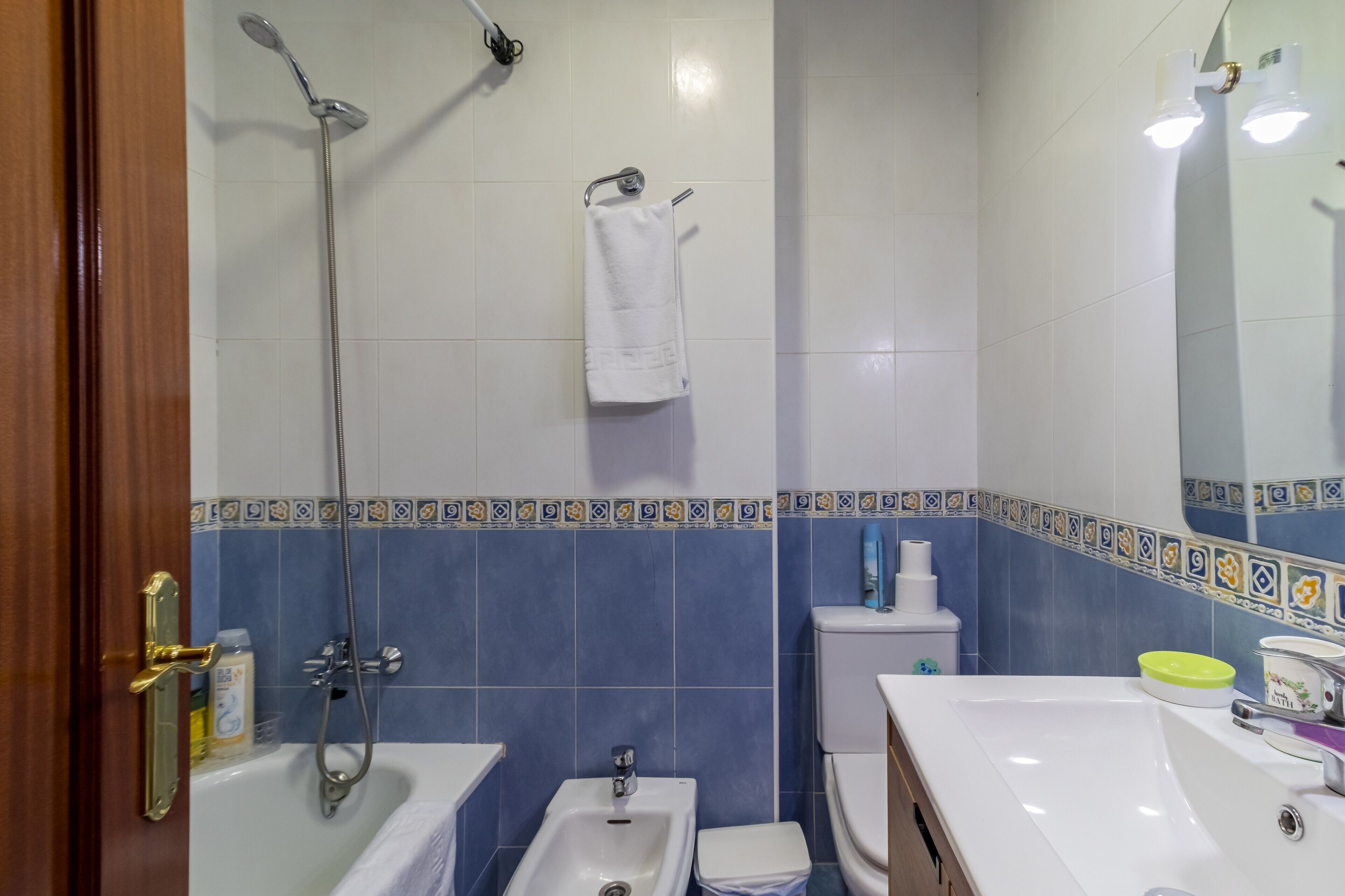 Un baño con bañera, ducha, lavabo, inodoro y espejo.