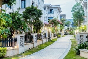 A residential street with houses, a paved walkway, and greenery. - Keister Villa Resort Hotel (Huangcuo Beach, Huandao Road) (Xiamen)
