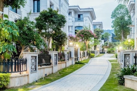 A residential street with houses, a paved walkway, and greenery.. Keister Villa Resort Hotel (Huangcuo Beach, Huandao Road)