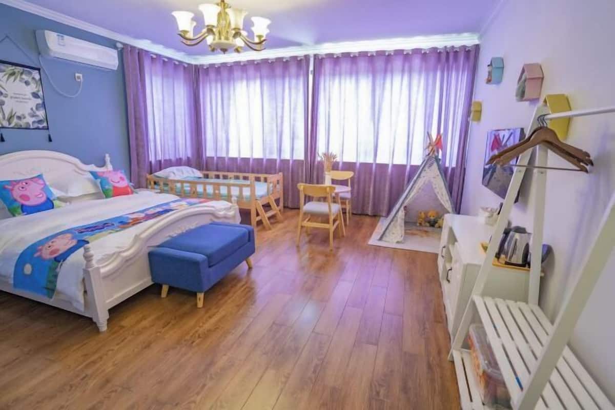 Un dormitorio con cama, escritorio, silla, una mesita y una estantería.