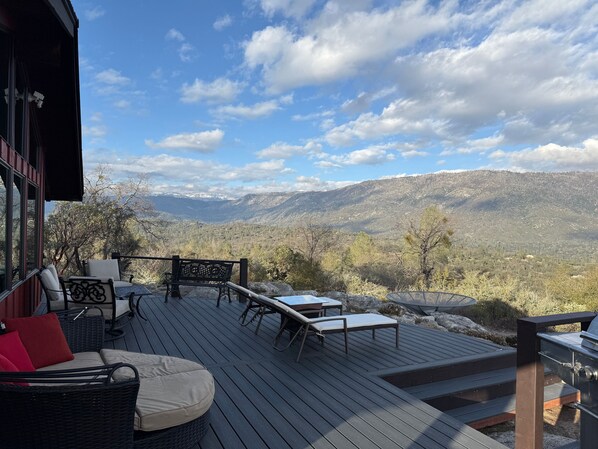 Terraza con mobiliario exterior, con vistas a un paisaje montañoso.