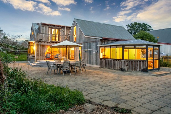 The home is surrounded by countryside, with a lovely outdoor area including outdoor furniture.