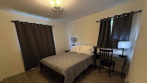 A small, clean room with a bed, a desk, and a chair. - Parham Bridges #1 5 Bedroom 2 Bath (Jackson)
