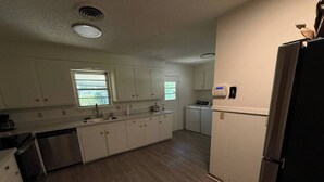 A kitchen with white cabinets, a dishwasher, a sink, and a window. - Parham Bridges #1 5 Bedroom 2 Bath (Jackson)