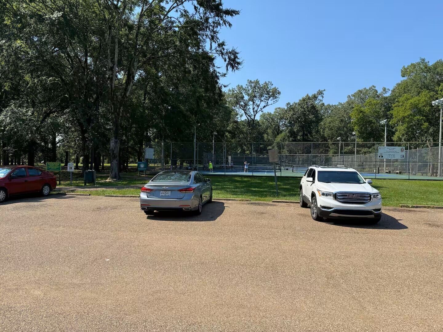 Un parking où sont garées trois voitures.