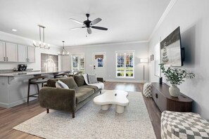 A spacious living room with a sofa, coffee table, and a TV mounted on the wall. - Hawthorne Haven - 2.3 mi to DT-Direct Trail Access (Bentonville)